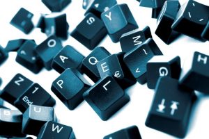 Pieces from a keyboard spread out, on white background