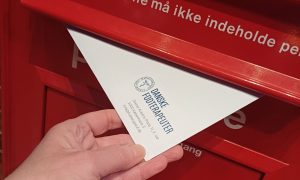 Cille Holse smider gavekortet til Henrik Møllgaard i en rød postkasse