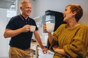 To kollegaer drikker kaffe sammen og griner. Foto: Jacob Lund fra iStock